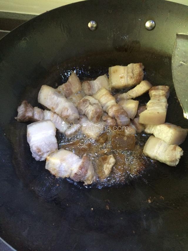 五花肉煸炒出一部分油后，加入红糖炒至融化。保持小火，不停翻炒。