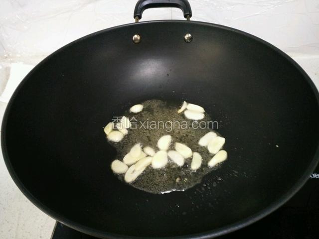 锅里注入油，加蒜片爆香。