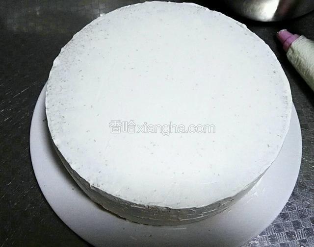 打好的奶油，三分之二装在裱花袋里，用剪刀剪出与裱花嘴大小的口，将裱花嘴安装好，剩下的三分之一奶油，用裱花刀将蛋糕表面及四周抹平，没有裱花台，我是用手转，尽量抹平