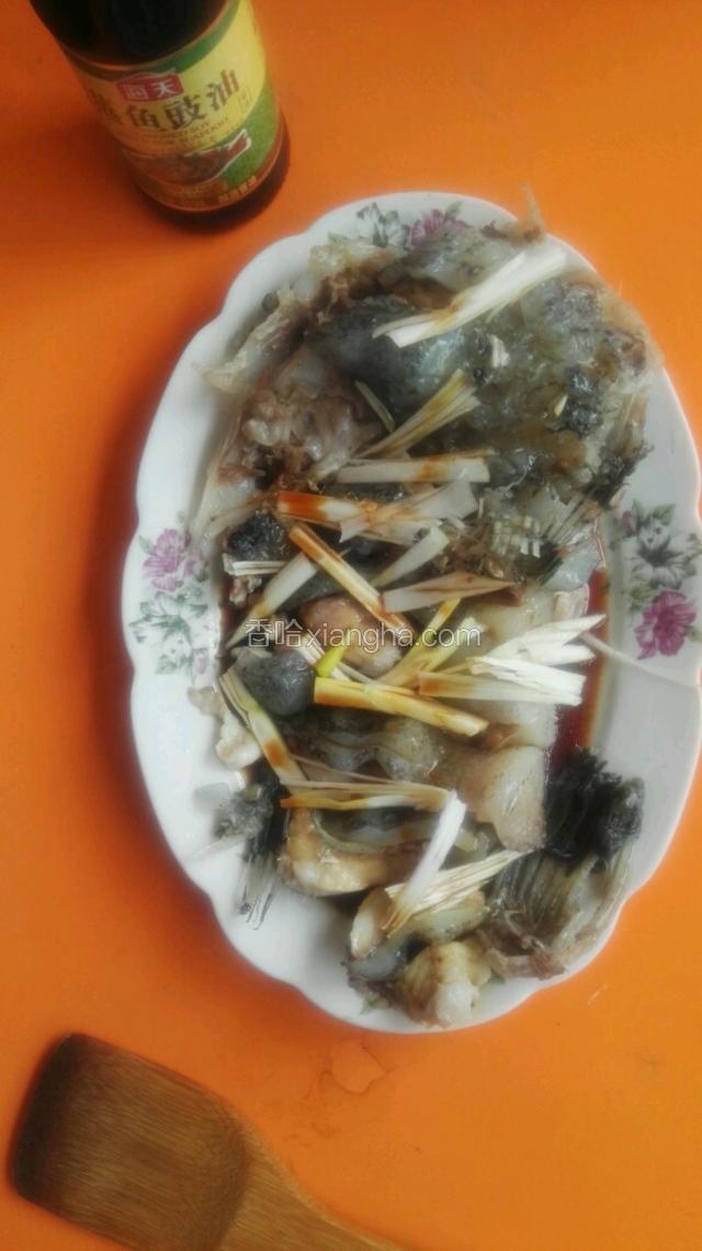 蒸好的鱼段倒出溢水后摆成鱼形，将葱丝放在鱼身上，淋适量蒸鱼豉油。