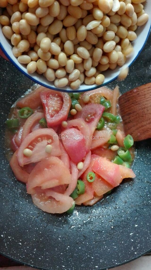 西红柿炒软后，倒入黄豆进行翻炒。