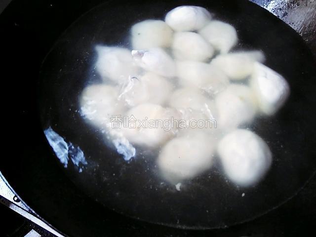 所有圆子入水中。稍稍晃动锅，使圆子不会粘在锅底。这时先不要用锅铲翻动，因为圆子刚入水还是湿的，一翻动很容易破损或几个粘在一起。开大火煮。