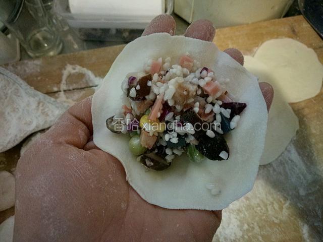 取一个面皮，中间添加适量馅儿料