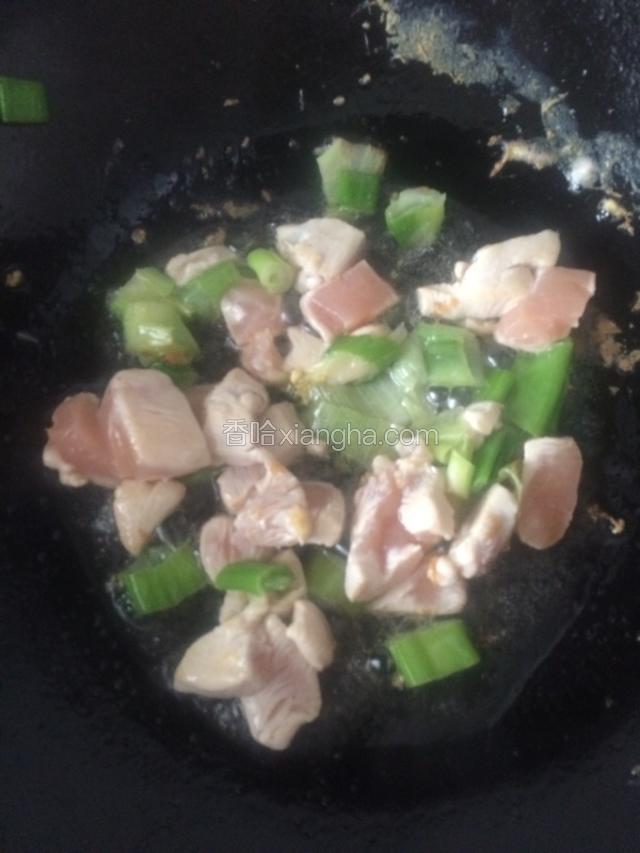 继续放入油，先把葱花炝锅，然后把鸡肉丁放入炒至变色。