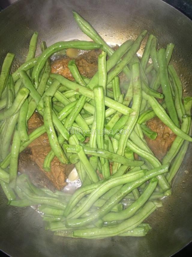 待30分钟后，放入洗好的豆角和盐，翻炒几下让汤汁没过豆角，继续小火慢炖20分钟。