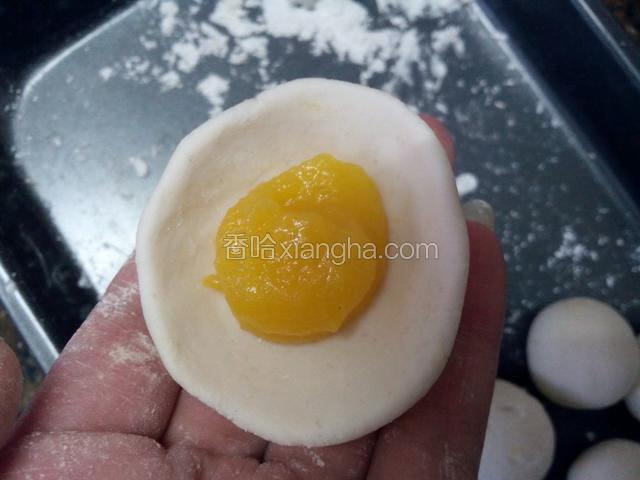 在面块的中间放入南瓜蓉，像包包子一样把面团收口，搓圆。