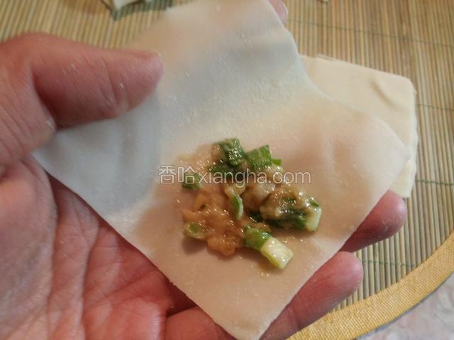 馅料先放在一个角边上，馅料不要太多，因为馄饨皮薄，煮时最多2分钟，肉多怕煮不熟，而且这样好吃，主要也喝热汤，想吃肉多直接饺子。