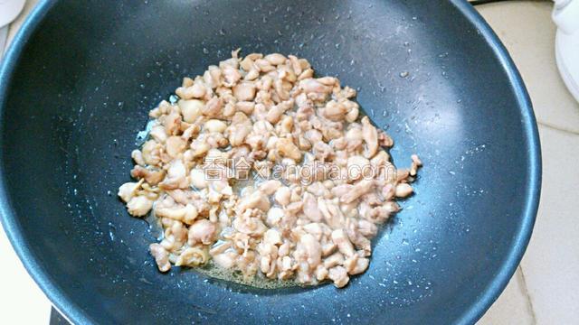 炒锅烧热倒入比平时炒菜稍多的油，油热放入鸡腿肉，煸炒至肉块变硬。