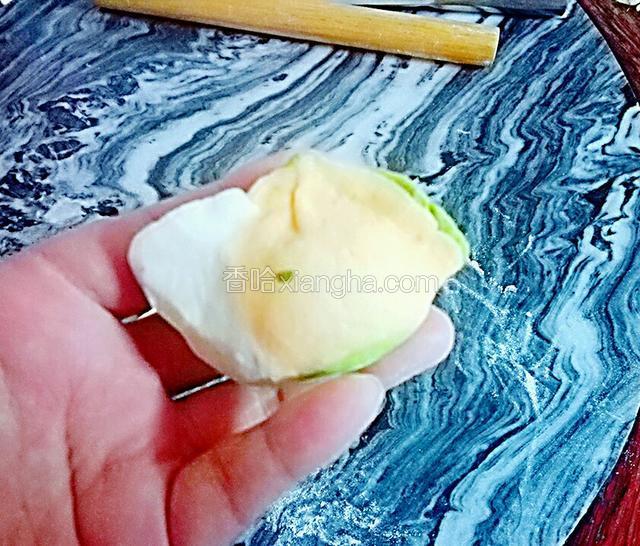 然后两边往中间折一点进去，再两只手的大拇子和食子拿住饺子同时用力按下饺，一个饺子就包好了