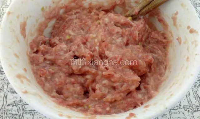 再加上一勺淀粉，一个蛋清，半杯水搅匀，水要一点一点的加，边加水边搅打，顺一个方向搅上劲，在放上葱末搅匀。