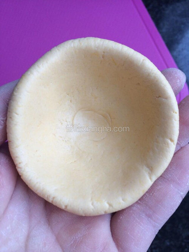 取一个剂子揉搓捏成圆窝状。（不会的直接按成薄饼状）