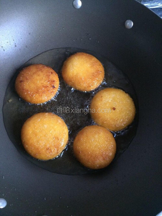 待油烧至七成热放入南瓜饼。改中小火并翻动南瓜饼，防止焦糊。