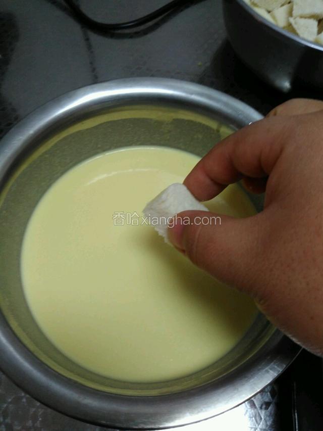 预热烤箱上下火150℃，将馒头丁放在蛋烧汁内裹匀
