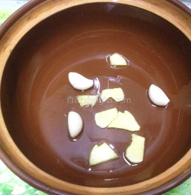 取一砂锅.码入几片姜、蒜头.