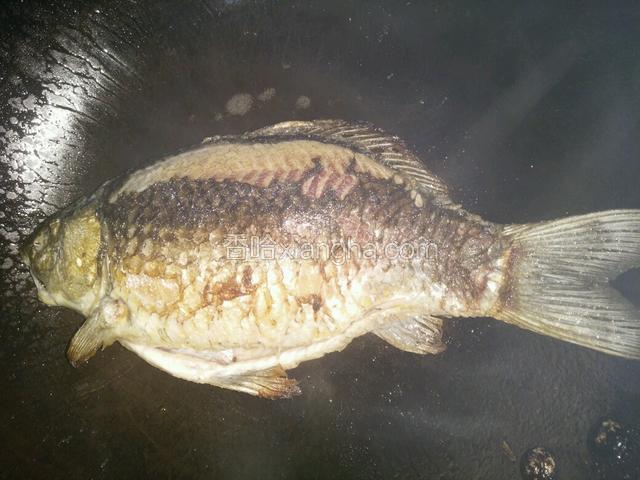 热锅，烧起青烟时加比平时炒菜多一倍的油，加入沥干水的鲫鱼煎至两面金黄，添干净盘子备用