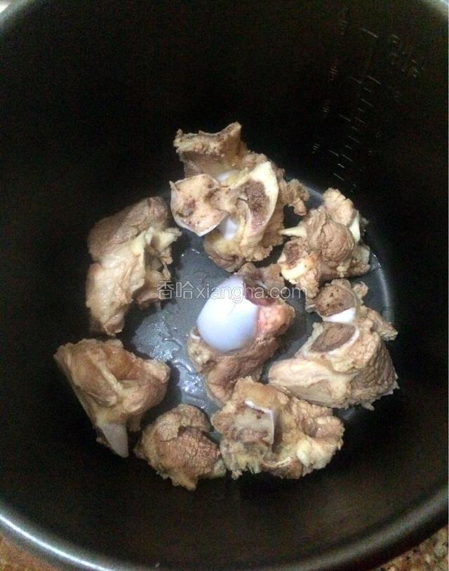 把洗净的筒骨倒入电饭锅内胆。