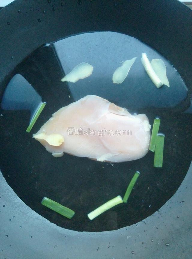 锅内加入水，烧开后装在碗里等会儿待用；锅内继续加入凉水，鸡脯肉下锅，放入葱段姜片。大火煮开，撇去浮沫，然后转中火煮8分钟。