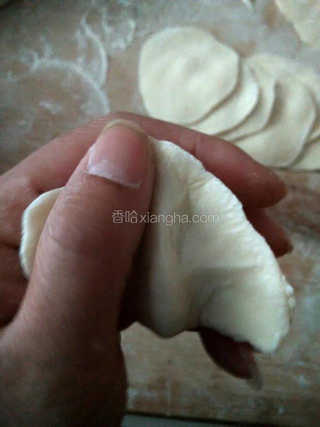 我一个人包没法拍，就是像这样两个大拇指并排放在面皮前面中间部分，后面的指头弯曲在面皮后，稍微用力挤压一下面皮成饺子状