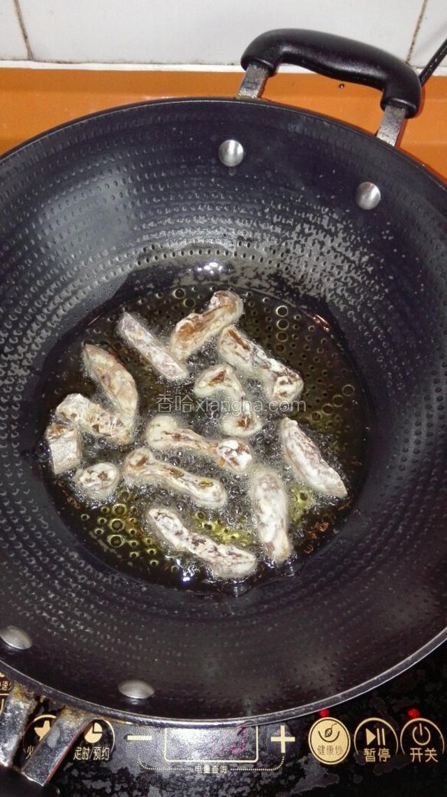 把柿饼用筷子一个一个夹入油锅，转中火炸