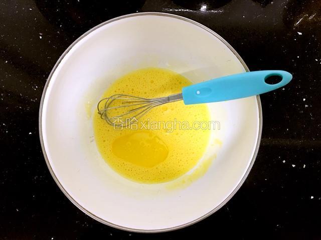 把玉米油倒入蛋黄液中。