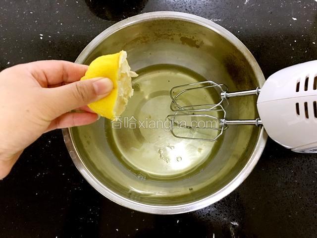 蛋白中挤入半个柠檬汁。