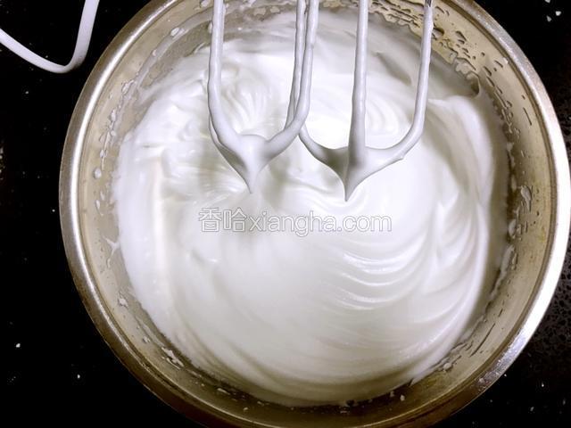打蛋器转为中速继续打发至蛋白成硬性发泡。硬性发泡就是提起打蛋器，蛋白成尖尖的角，不弯不塌。
