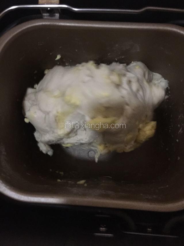面包机一个揉面程序后，加入黄油后继续搅拌成团。