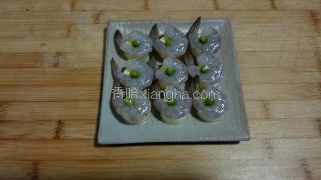 将剥好的虾放到豆腐上面，中间放一粒豌豆。
