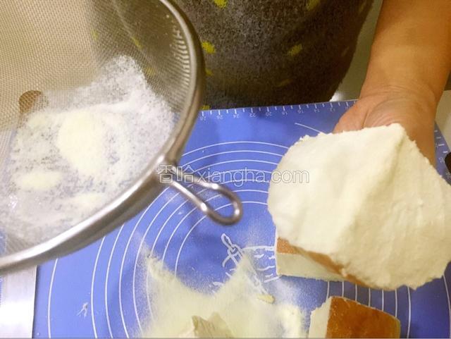 四块都抹匀后，取奶粉，用面粉筛在面包的切面上撒上奶粉。
