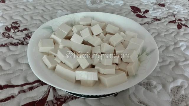 将泡好的豆腐沥干水切成小块。