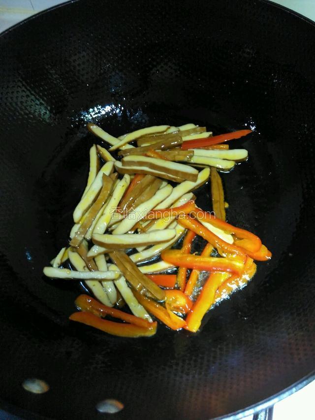 接着倒入香干炒匀