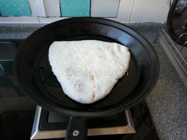 用手按成三角形状肉饼(正反两边按这样薄厚一样)放入提前预热饼铛上，小火盖上盖烙制