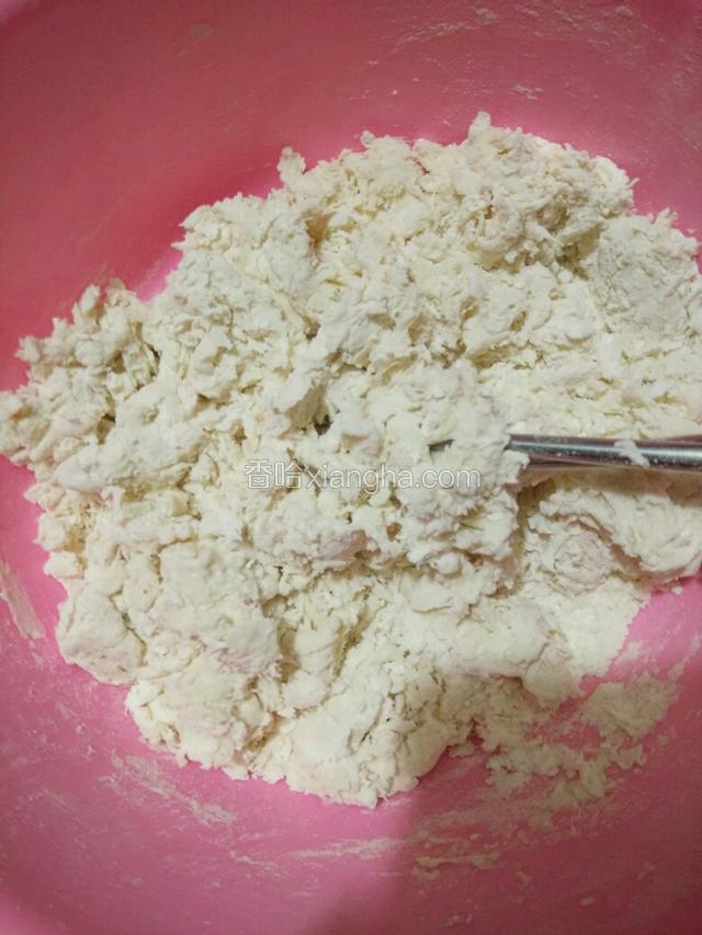 左手拿酵母水碗往面粉里倒，右手拿筷子不停搅和面粉，成大片的棉絮状（水不够就加点温水，宁少勿多，因为碗里的水中全是酵母呢）