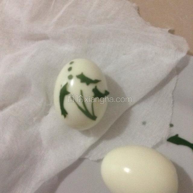 将树叶剪影贴在鸡蛋上。