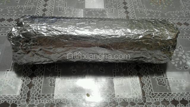 蛋糕正面朝上，还用原来那张锡纸把蛋糕卷起卷紧，放入冰箱冷藏一小时定型！