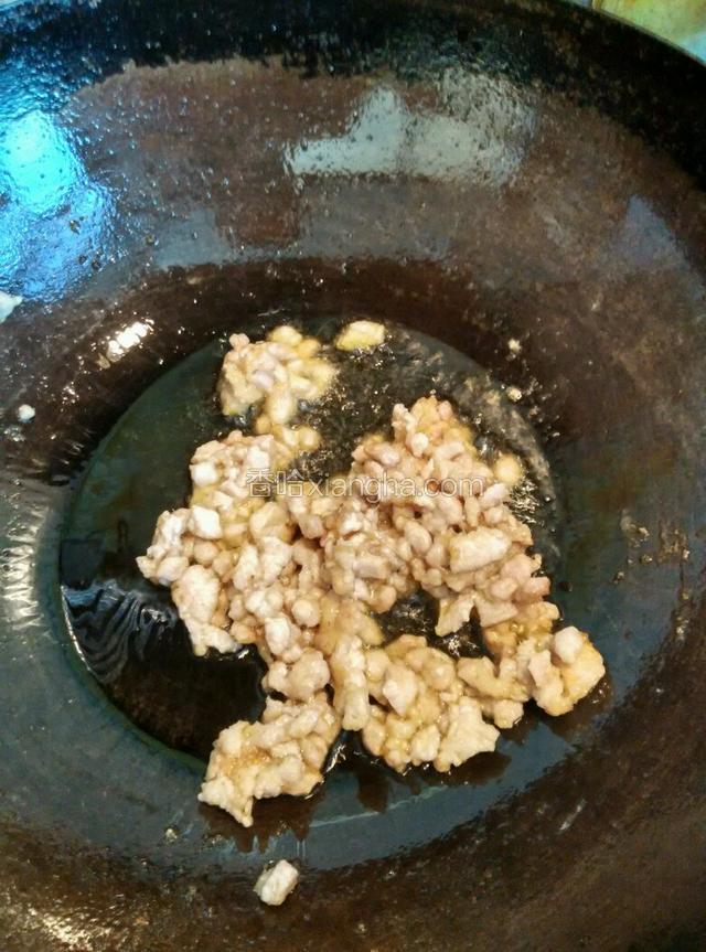 锅内倒适量油，凉锅下拌好的肉丁，小火快速翻炒滑散肉丁至变色