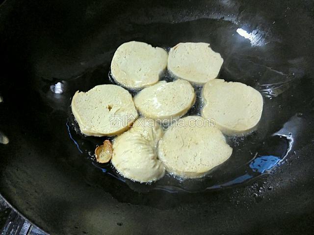 油温六七成，放入素鸡片用小火慢煎。