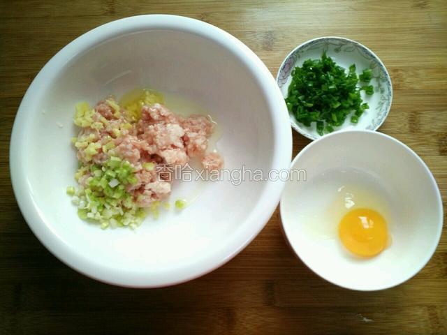 取一大点的容器，加入肉馅、葱白、姜粒、一个蛋清(葱叶备用、蛋黄不加入)。