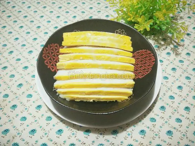 用刀尖沿碗边划一圈，倒扣案板上，小心取出糕体，稍晾凉后切片，装盘