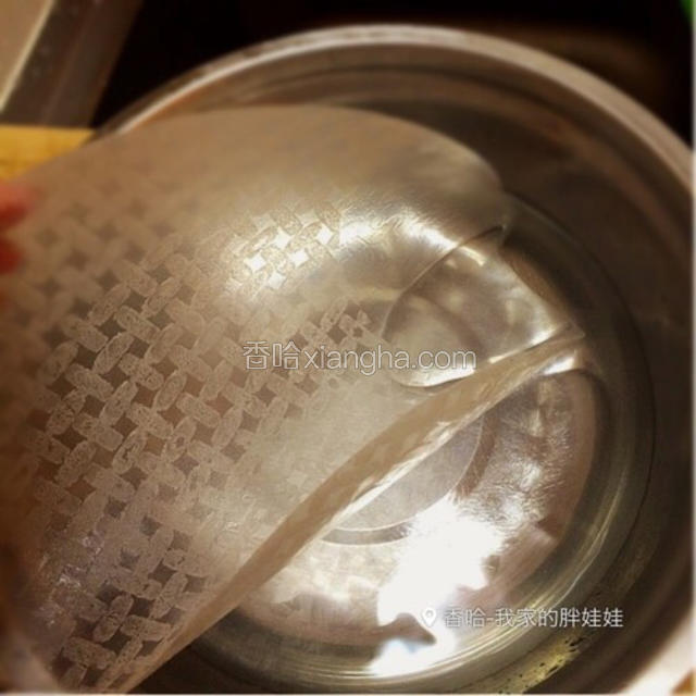 用容器装一半温热水，慢慢地放一张春卷皮进温水里，一定要慢