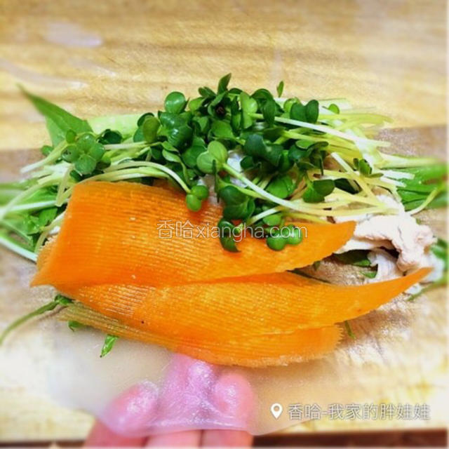 春卷皮上第一层放水菜，然后放里脊肉片，再放胡萝卜片、黄瓜、萝卜苗
