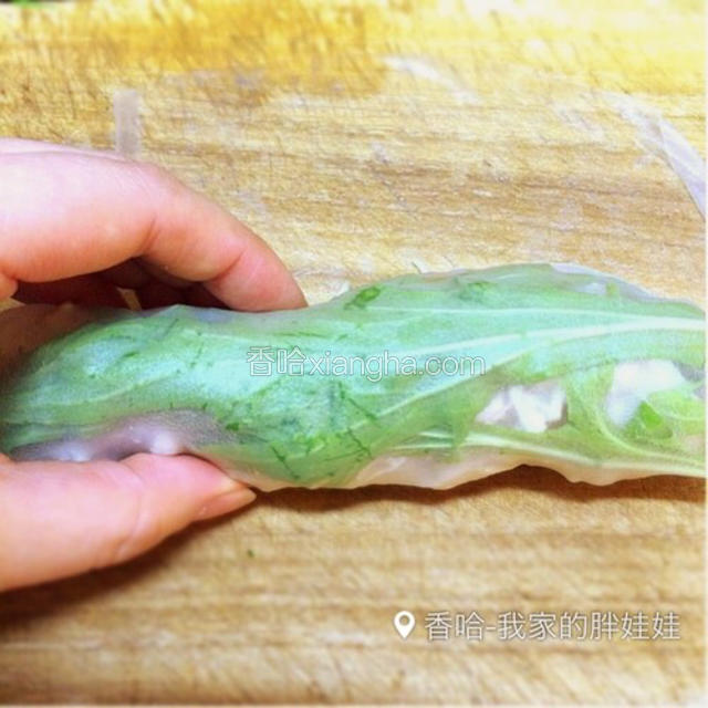蔬菜放好后，然后把春卷皮从里端慢慢把放好的蔬菜包裹起来