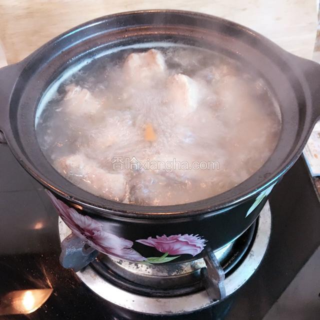 取砂锅加入适量开水、猪骨。大火煮沸转小火慢煲。转小火时盖上锅盖