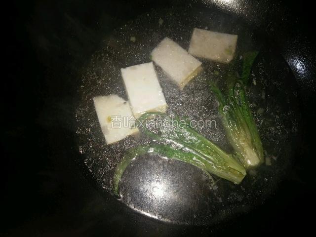 将青菜和鱼糕片入煮粉的锅里稍烫