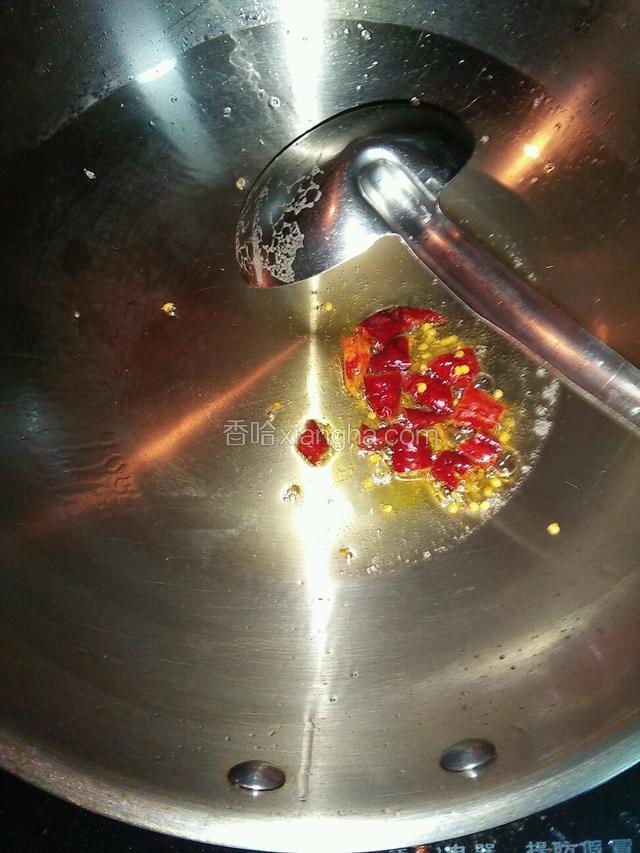 虾尾焯水的同时，另起锅入油，先将树椒段小火炒酥，颜色变鲜红。