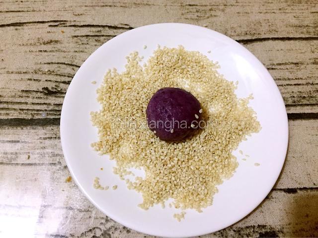 再放入白芝麻滚一圈，让其表面都裹上白芝麻