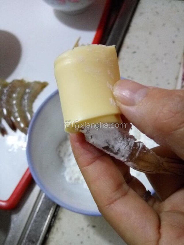 虾蘸淀粉，然后卷上乳酪片。