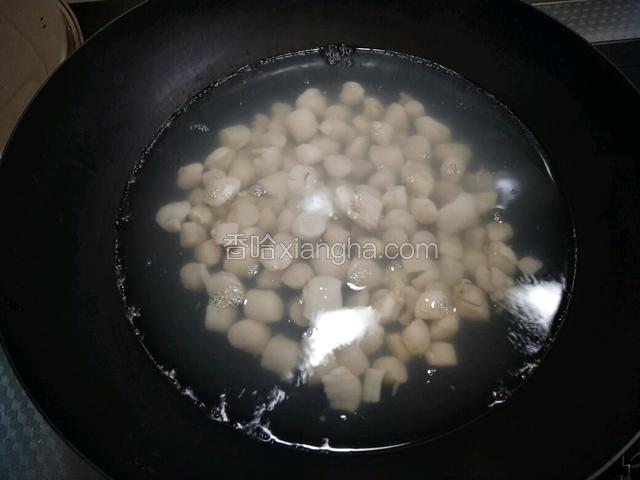 锅中再防水烧至七八分开时，放入扇贝丁焯水