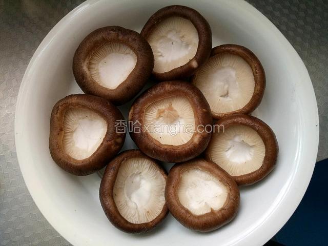 浸泡后洗干净去掉香菇蒂，正面朝下摆放在盘中备用