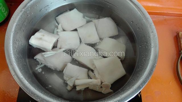 取一不锈钢盆加入适量凉水放入猪蹄，水开后焯五分钟